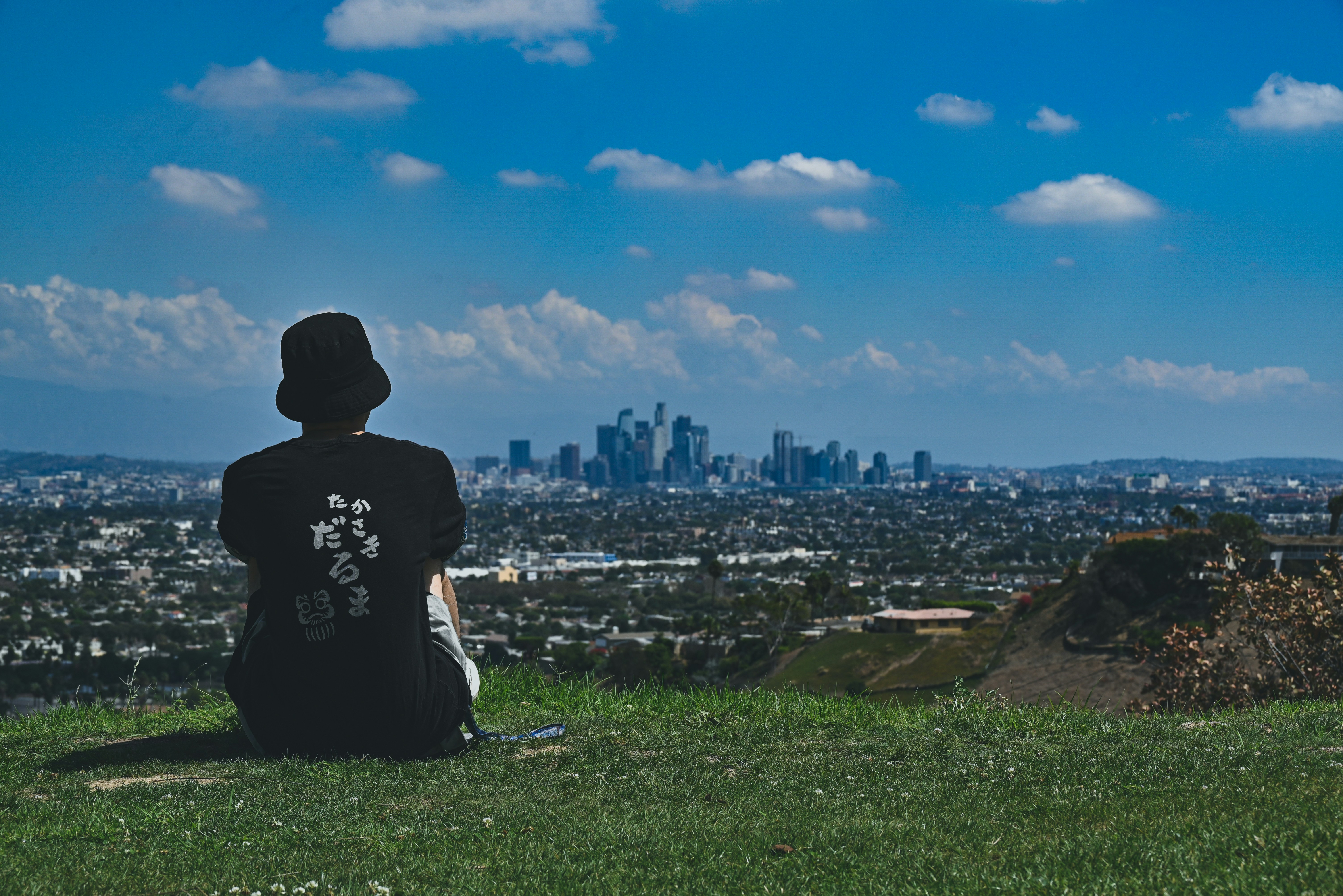 A person sitting on a hill overlooking a city