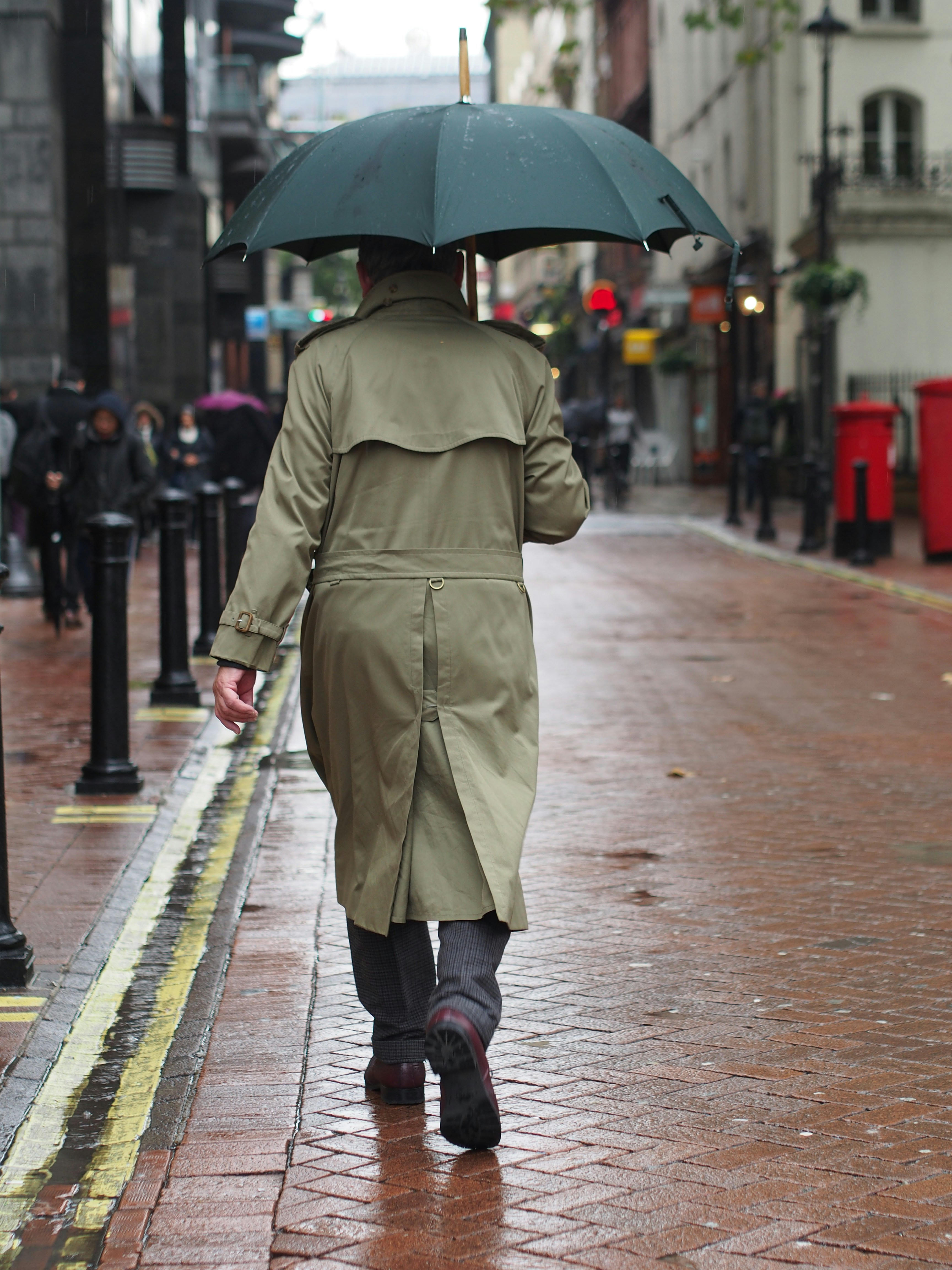 a person walking down a sidewalk with an umbrella