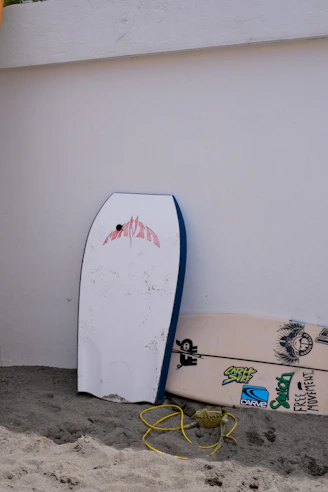 a couple of surfboards leaning against a wall