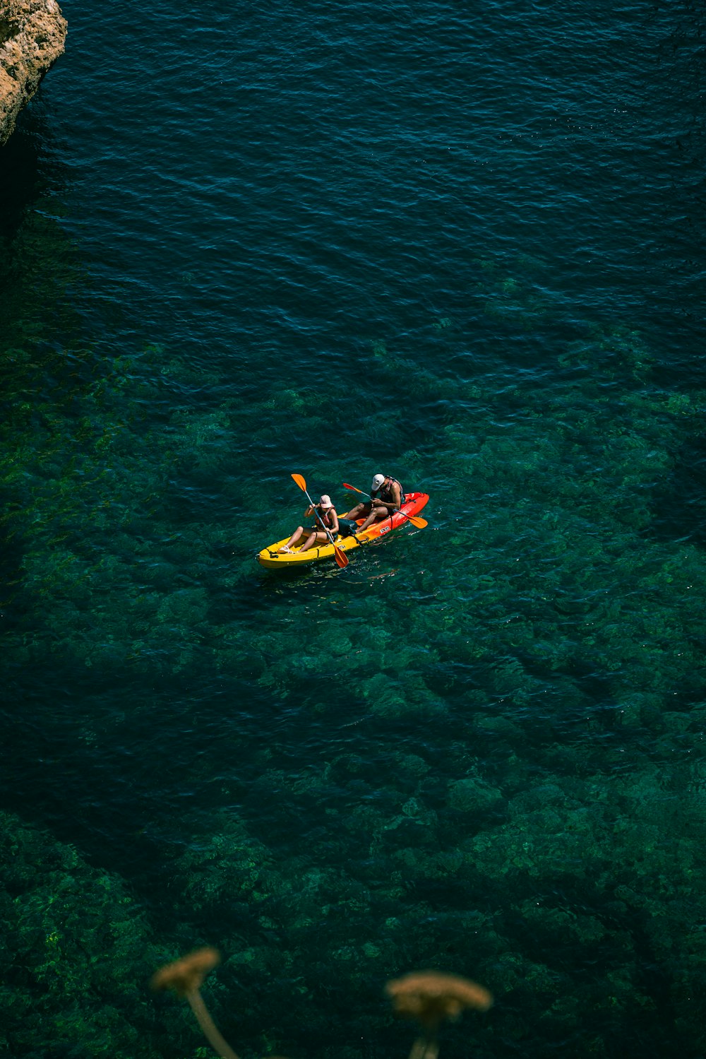 a group of people in a yellow kayak on a body of water