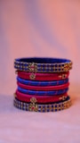 A vibrant display of colorful artificial bangles stacked neatly on a wooden stand