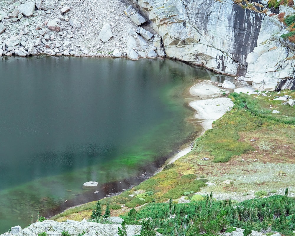 a body of water with rocks and grass around it