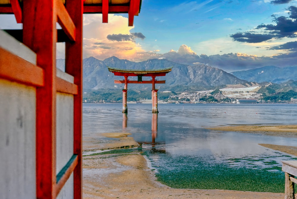 a red building with a red archway over a body of water