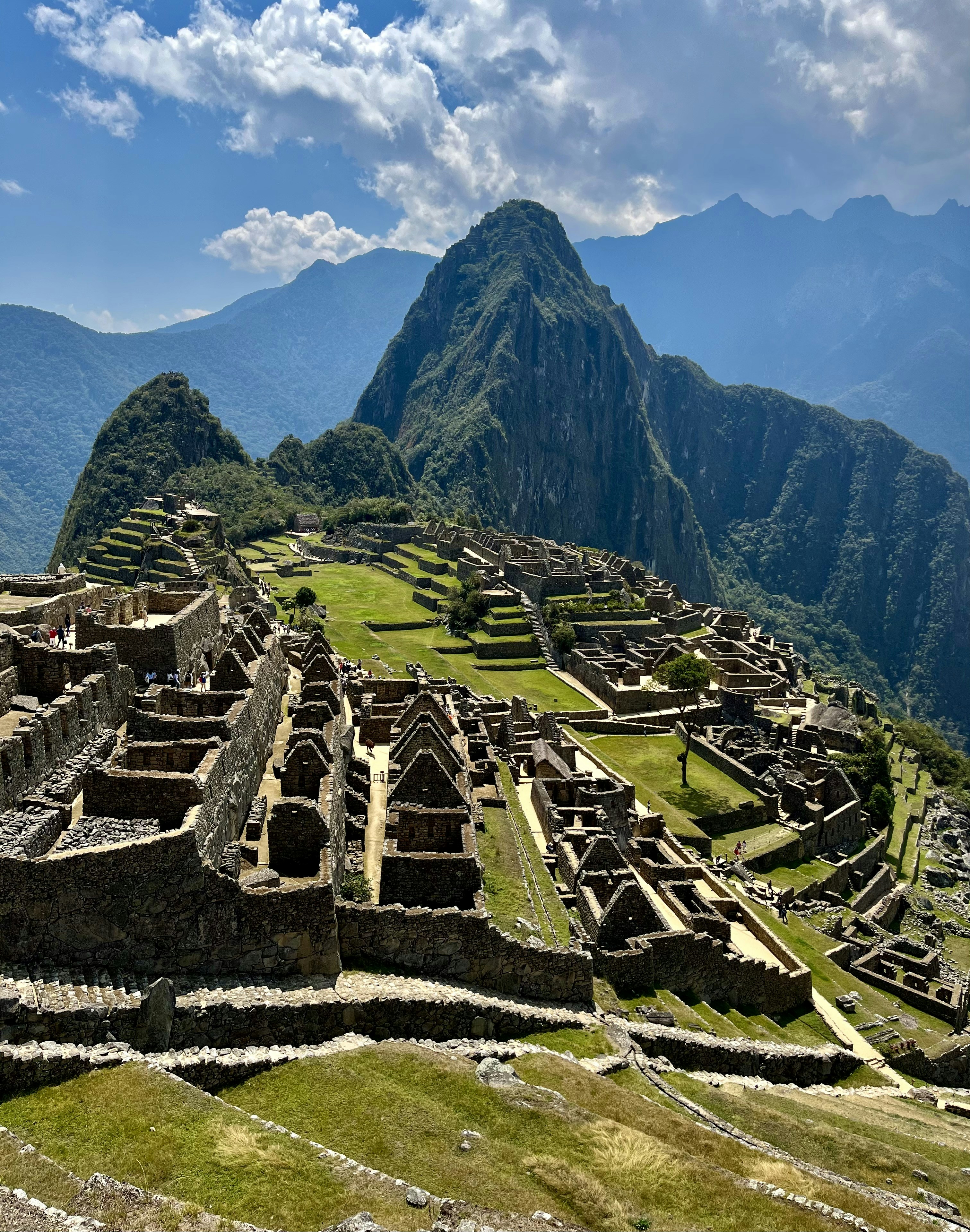 an old city with mountains in the background with Machu Picchu in the background