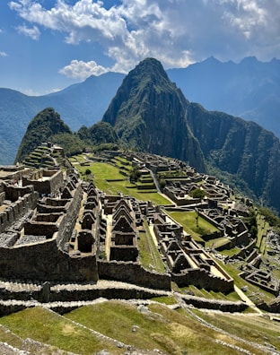 an old city with mountains in the background with Machu Picchu in the background