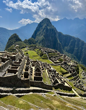 an old city with mountains in the background with Machu Picchu in the background