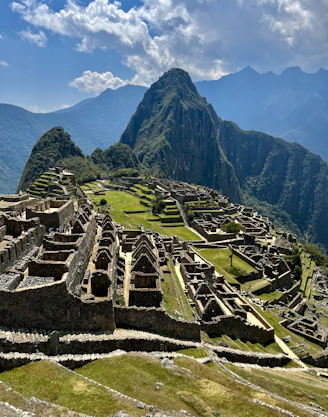 an old city with mountains in the background with Machu Picchu in the background