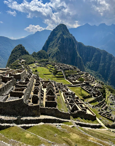 an old city with mountains in the background with Machu Picchu in the background