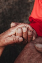 Hands of a caregiver and client clasped together, symbolizing trust and support.
