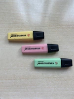 A set of vibrant yellow highlighters neatly arranged on a wooden desk