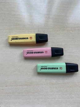 A set of vibrant yellow highlighters neatly arranged on a wooden desk