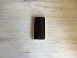 Close-up of a sleek modern smartphone on a wooden table.
