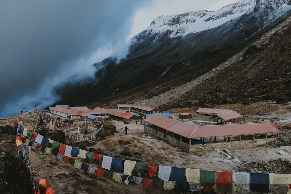 Un groupe de personnes debout sur une colline avec un bâtiment et des montagnes en arrière-plan