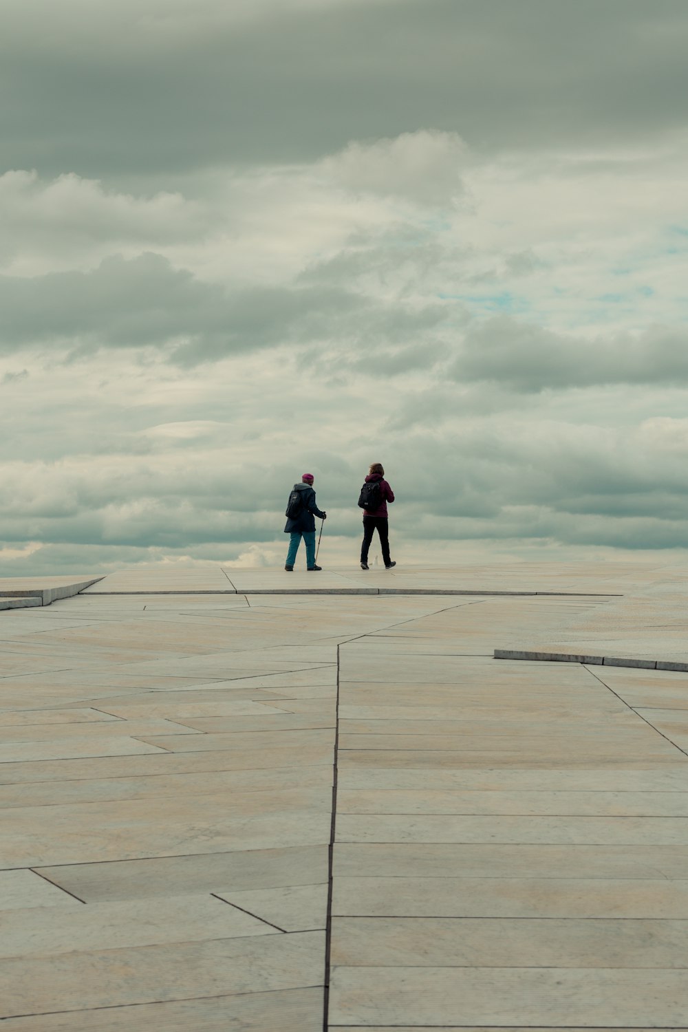 two people walking on a boardwalk