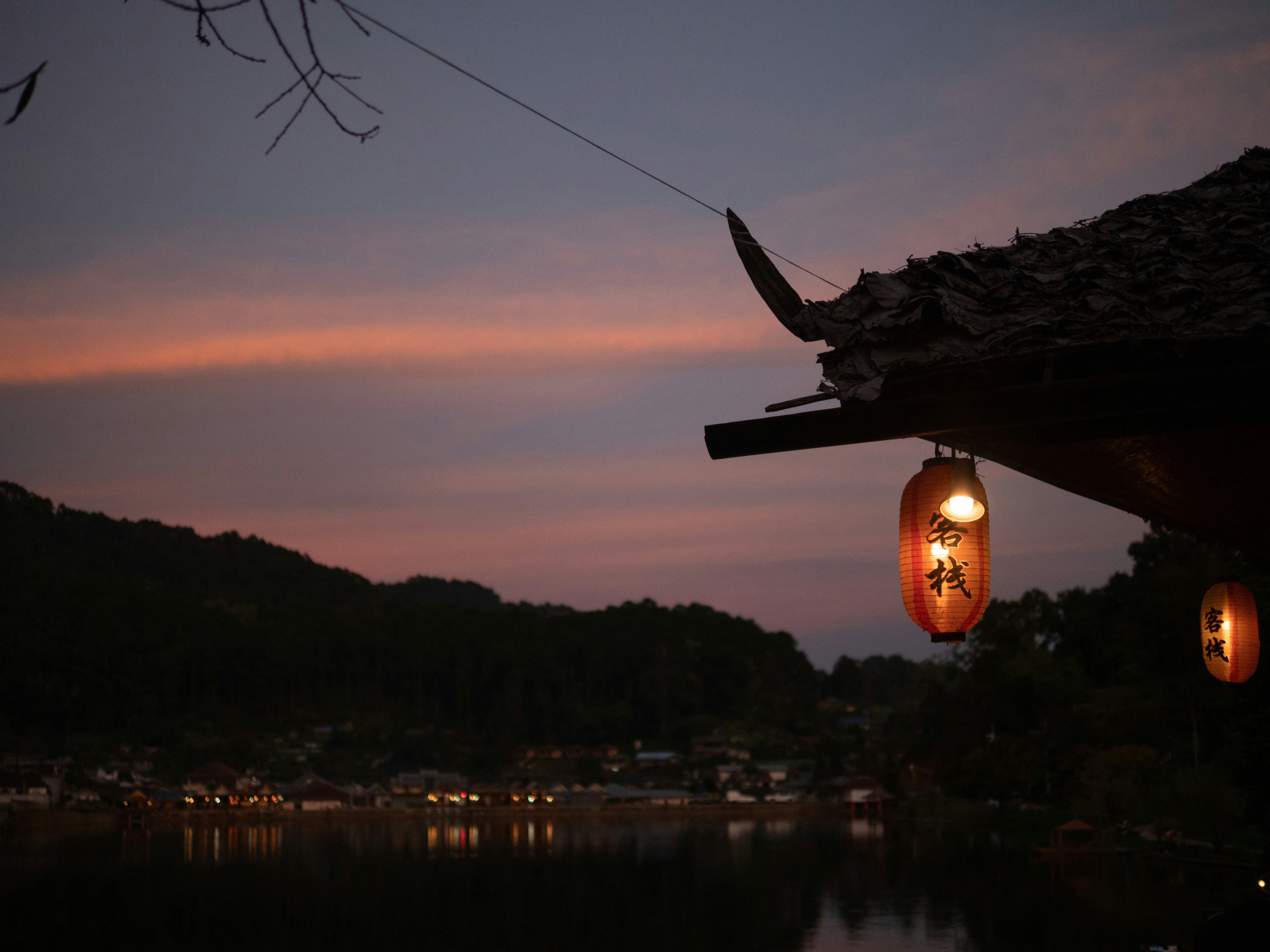 Traditional Japanese soba restaurant exterior with noren and lanterns at dusk