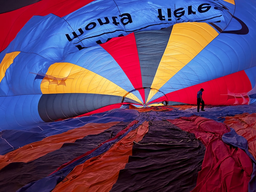 a person standing in front of a group of colorful kites