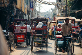 a person riding a bicycle next to a cart full of people