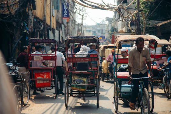 a person riding a bicycle next to a cart full of people