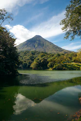 a lake with trees and a mountain in the background