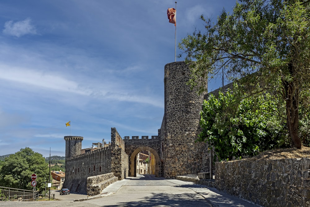 un mur de pierre avec un drapeau dessus et un mur de pierre avec des arbres