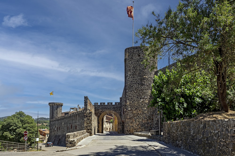 a stone wall with a flag on it and a stone wall with trees