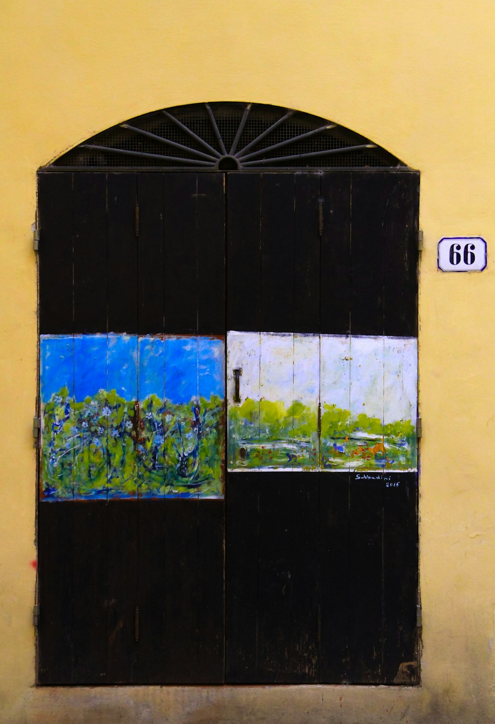 a yellow wall with a black door