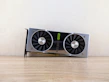 High-performance graphics card resting on a minimalist black surface with soft lighting.