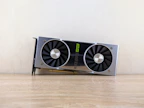 High-performance graphics card resting on a minimalist black surface with soft lighting.