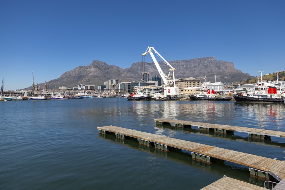 a body of water with boats and a crane in the background