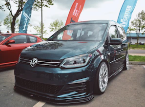 A sleek, modern transport van branded with the vektora logo parked by a city street.