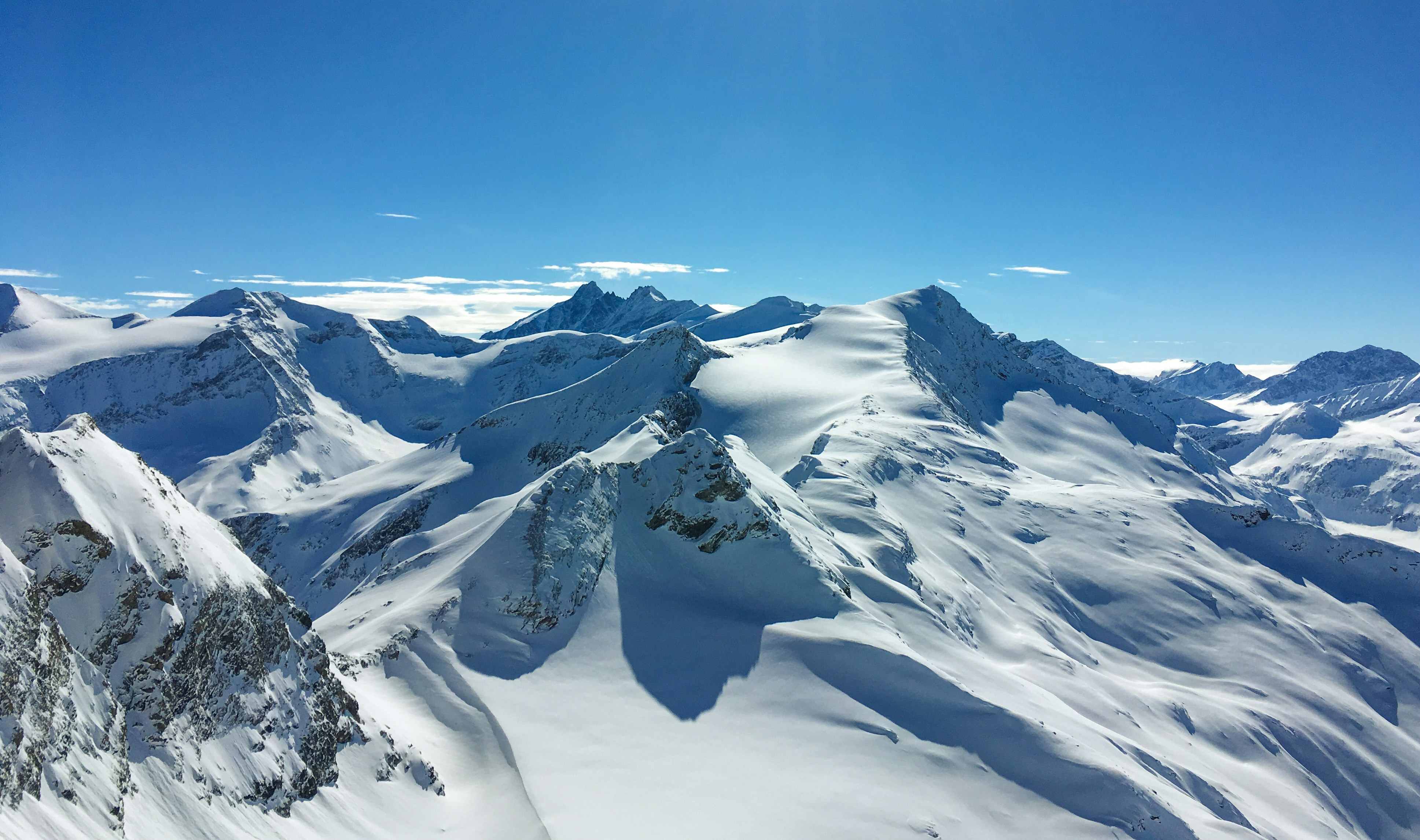 Snow-covered mountain range under a clear blue sky