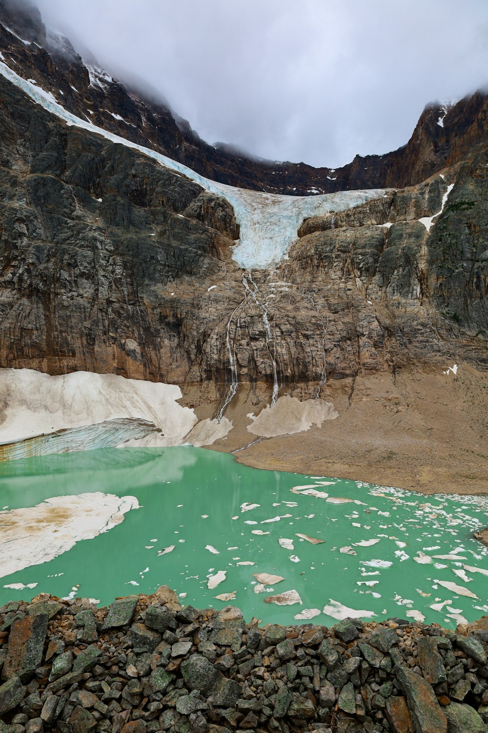 a body of water with ice and rocks by it