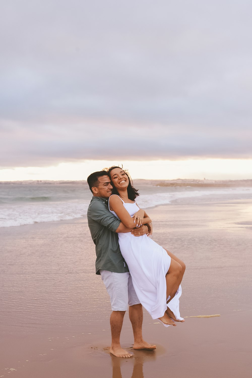 a man and woman kissing on a beach