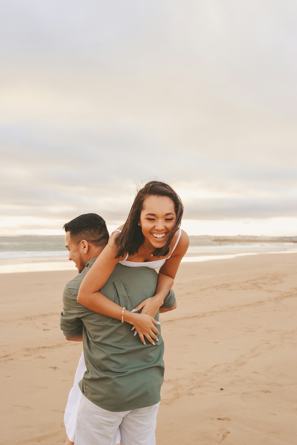 a man and woman hugging on a beach