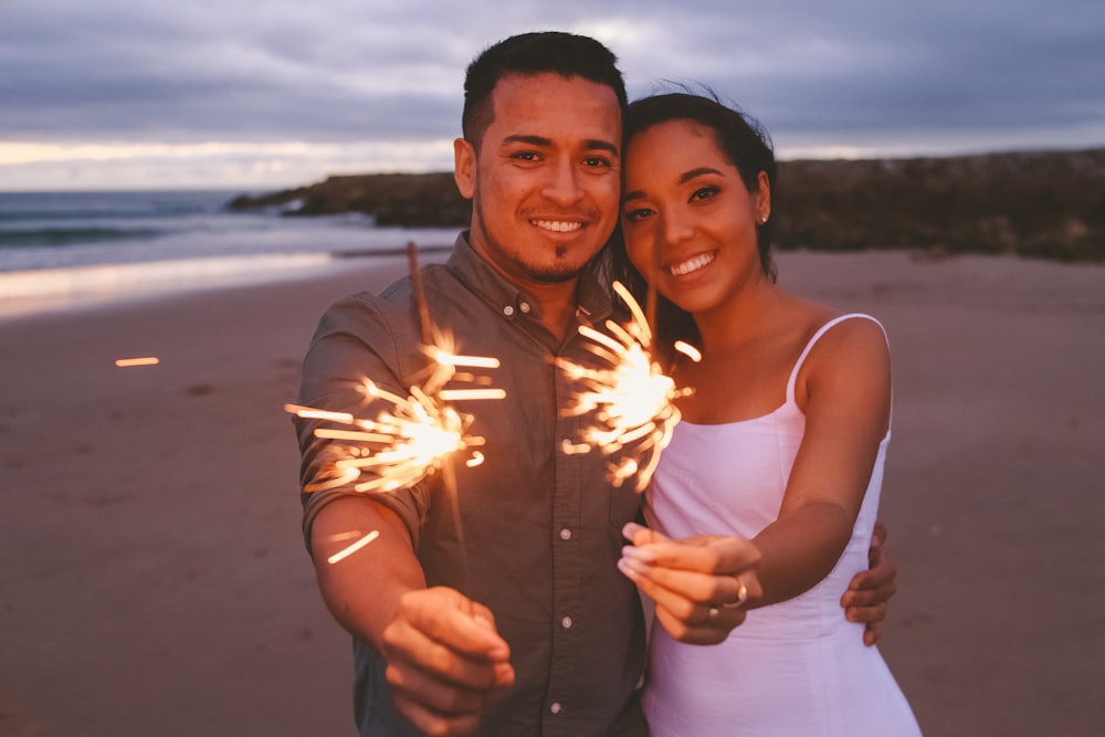 a man and woman posing on a beach