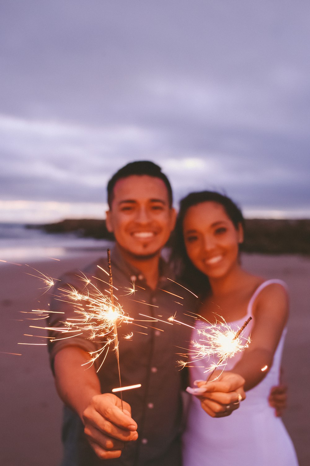 a man and woman holding sparklers