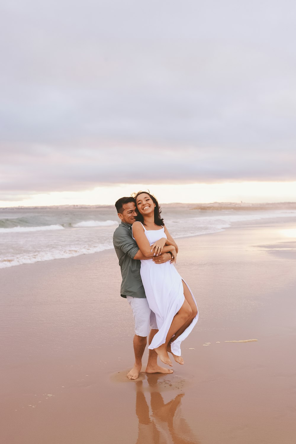 a man and woman kissing on a beach