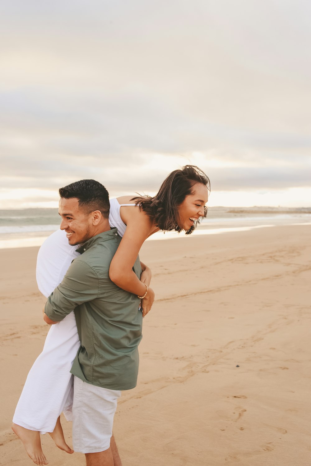 a man and woman hugging on a beach