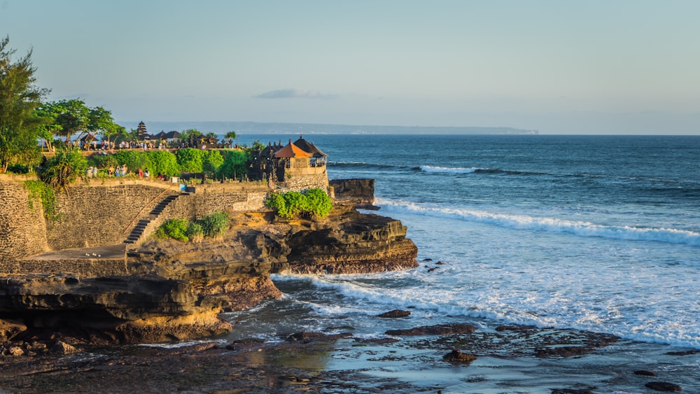 a building on a rocky cliff by the ocean