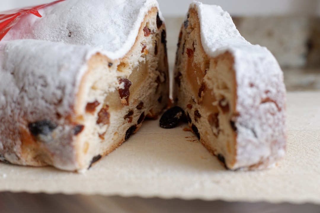 a slice of cake with a slice taken out, Stollen cake with a slice being cut from it displaying the inside