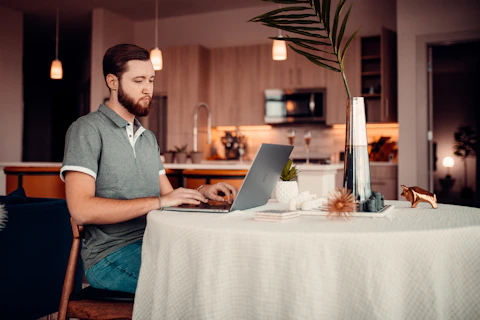 a person sitting at a table with a laptop