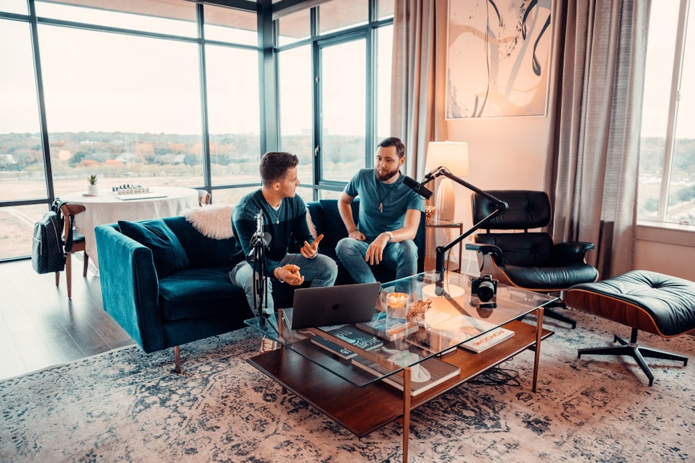 a couple of men sitting on a couch in a living room