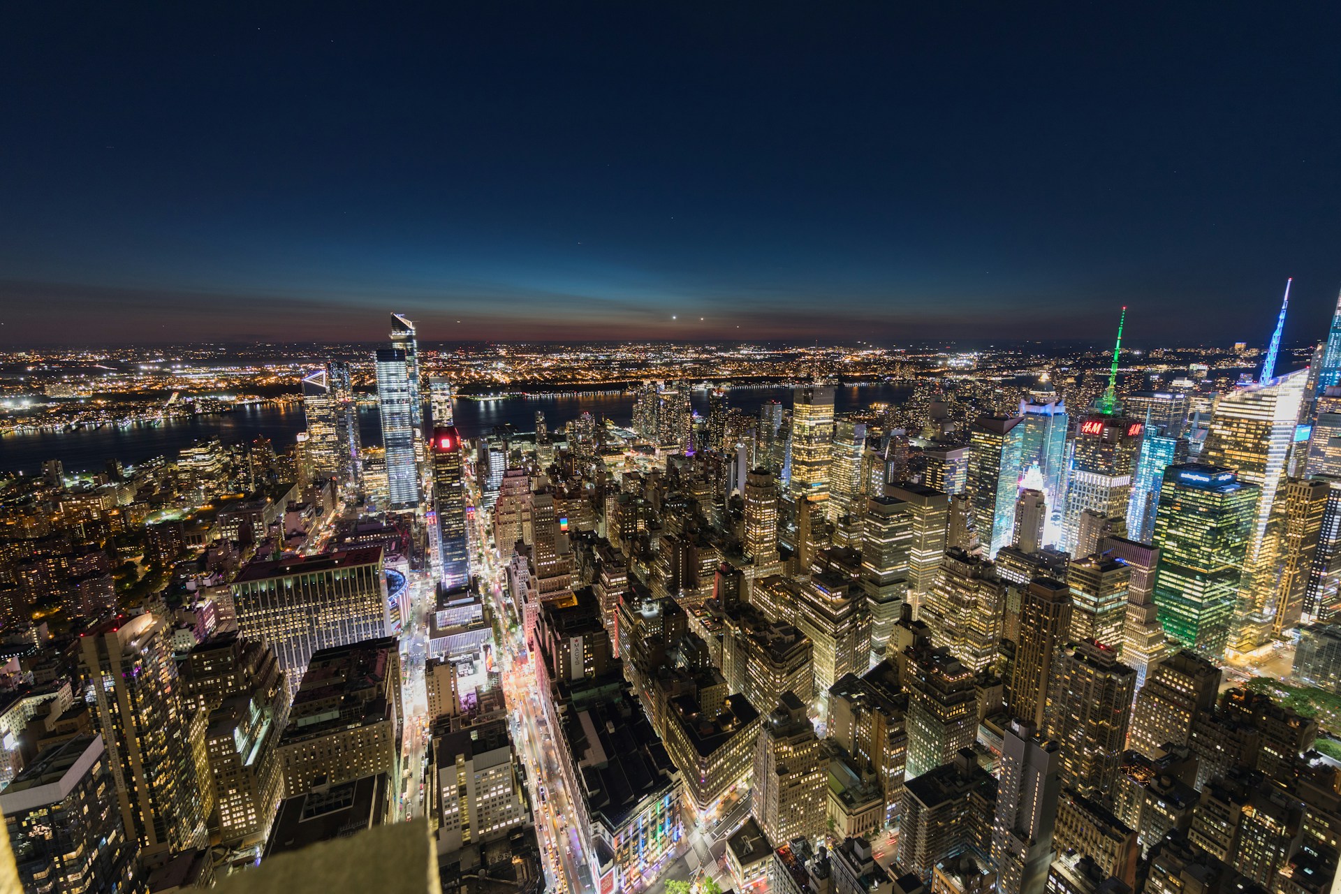 A stunning nighttime aerial view of downtown Dubai, showcasing the illuminated Burj Khalifa piercing the sky with a backdrop of shimmering city lights.