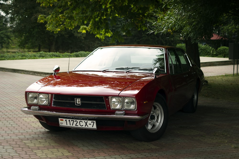 a red car parked on a brick road