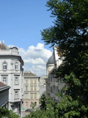 A bustling European street framed by historic architecture under a soft cream sky.