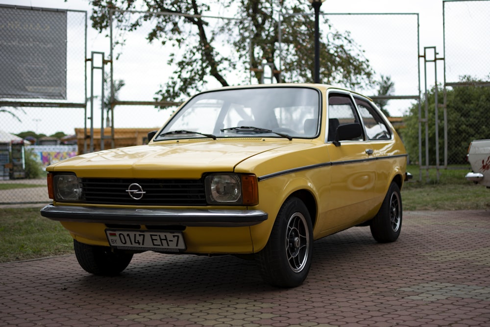 a yellow car parked on a brick road