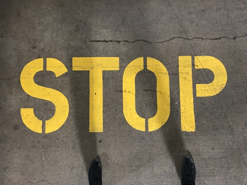 Aggressive typography spelling out 'STOP' in heavy black letters with red slashes.