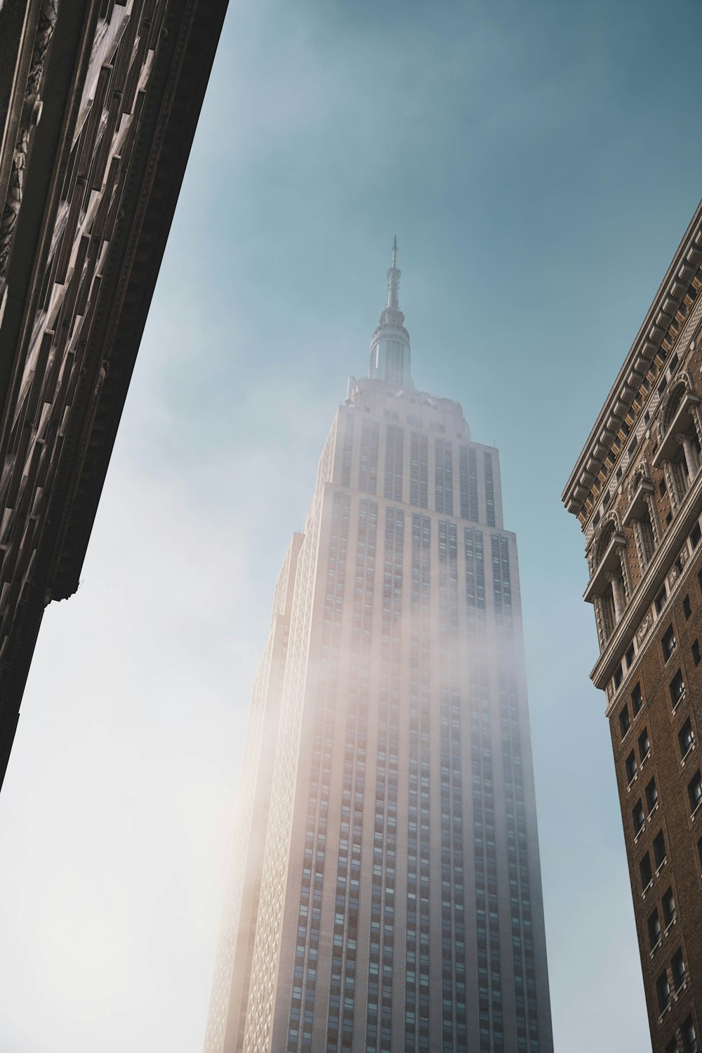 un edificio alto con una cima appuntita con Empire State Building sullo sfondo