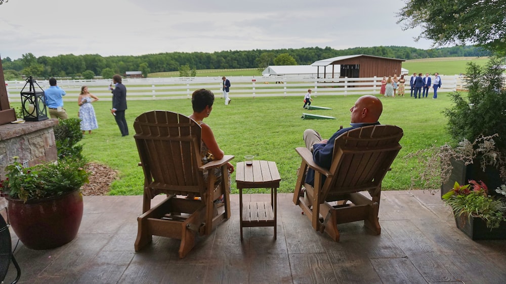 two people sitting in chairs on a deck