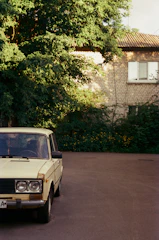 An old classic car parked on a quiet street, showing acceptance of older vehicles.